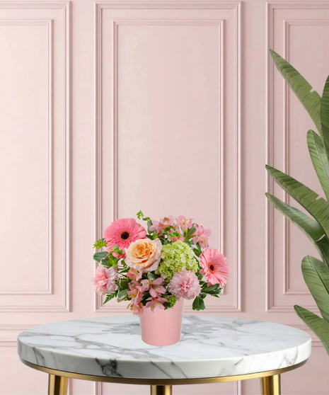 To Mom, With Love Mother's Day flower arrangement featuring peach roses, gerbera daisies, lime-green mini hydrangeas, and pink carnations in a matte pink vase.