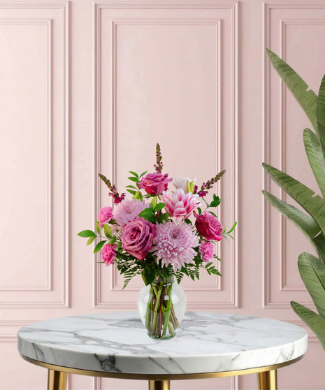 Lady Lavender Mother's Day flower arrangement featuring lavender roses, pink lilies, pink chrysanthemums, and magenta snapdragons in a clear glass flared vase.