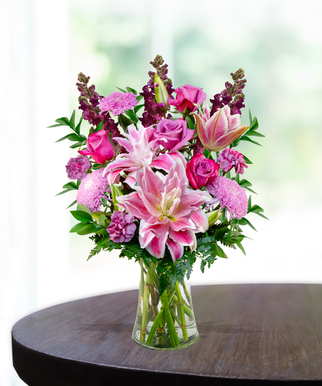 Lovely Lavenders everyday flower arrangement with rose lilies, roses, snapdragons, and lavender mums in a clear vase.