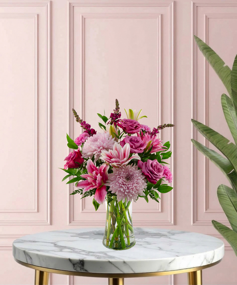 Lady Lavender Mother's Day flower arrangement featuring lavender roses, pink lilies, pink chrysanthemums, and magenta snapdragons in a clear glass flared vase.