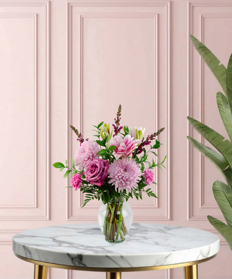 Lady Lavender Mother's Day flower arrangement featuring lavender roses, pink lilies, pink chrysanthemums, and magenta snapdragons in a clear glass flared vase.