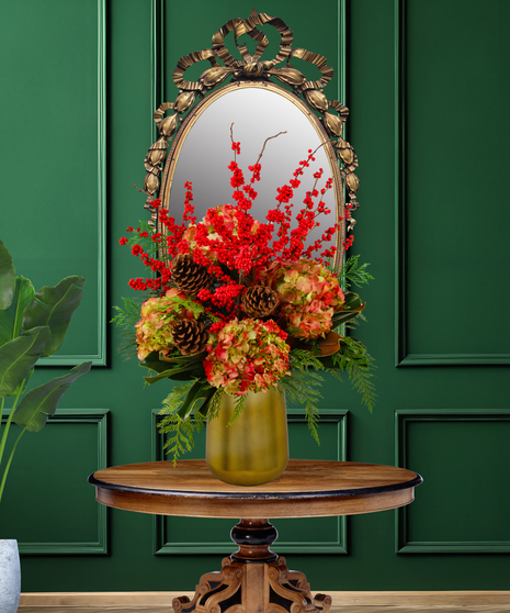 Lush Holiday arrangement with red Ilex berries, russet hydrangeas, and pinecones in a golden-green vase from Billy Heroman's.