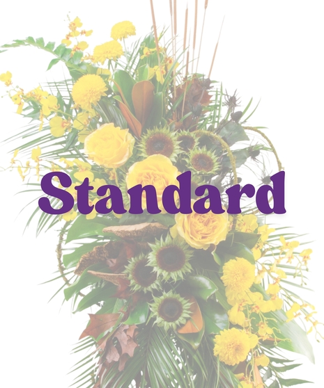 Meadow of Memories traditional funeral standing spray featuring yellow roses, cascading yellow orchids, naked sunflowers, and cattails on a wire easel.