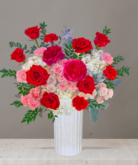 P.S. I Love You flower arrangement with red roses, pink garden roses, blush spray roses, and hydrangeas in a tall white vase