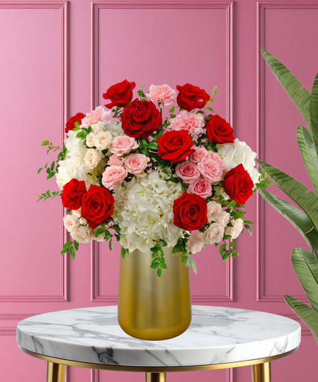 P.S. I Love You luxury Valentine's arrangement with red roses, red garden roses, white hydrangeas, and pink spray roses in a satin gold metallic vase.