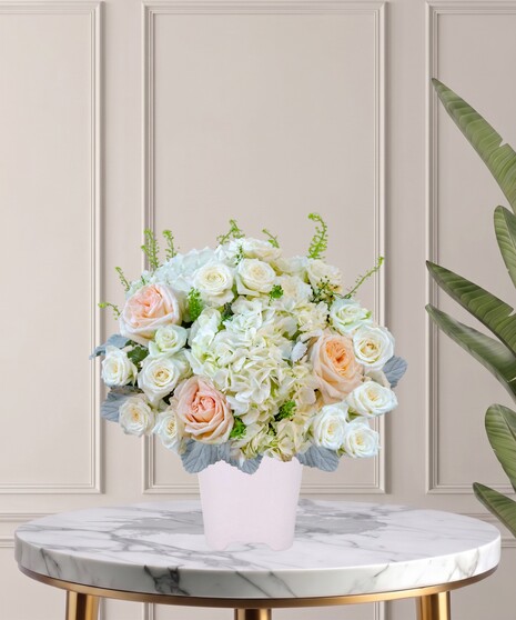 Billy Heroman's Signature Collection white and blush flower arrangement with roses, hydrangeas, and greenery in a textured white vase