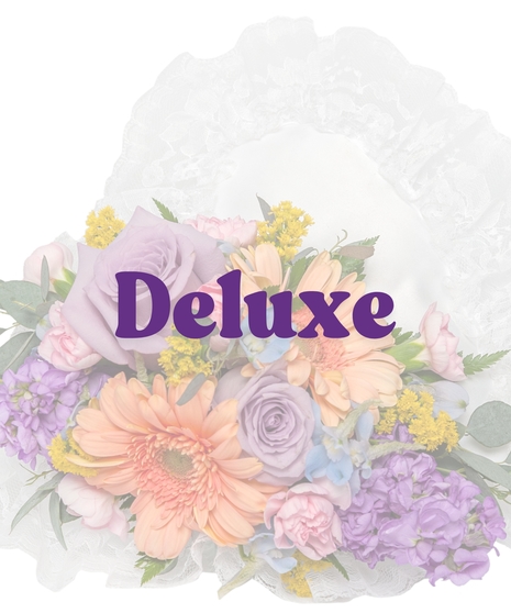 Pastel floral casket lid pillow with gerberas, lavender roses, and stock on a white satin heart base from Billy Heroman’s in Baton Rouge