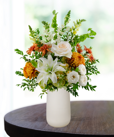 Topaz to Remember November birthday flower arrangement with white lilies, white roses, orange mums, and green Bells of Ireland in a white vase