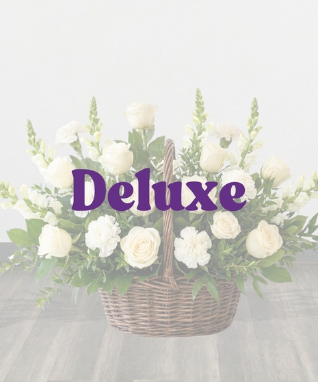 Purity Basket white sympathy flower arrangement featuring white roses, white carnations, white snapdragons, and lush green foliage in an 8-inch dark woven basket with a handle