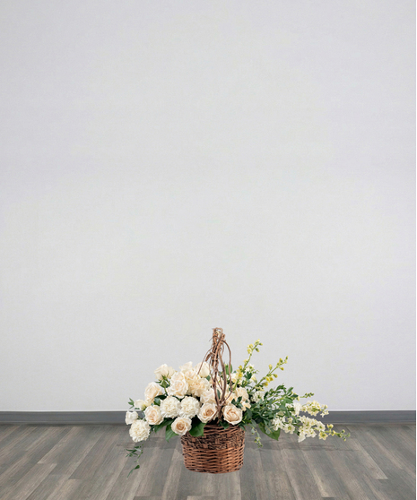 Purity Basket white sympathy flower arrangement featuring white roses, white carnations, white snapdragons, and lush green foliage in an 8-inch dark woven basket with a handle