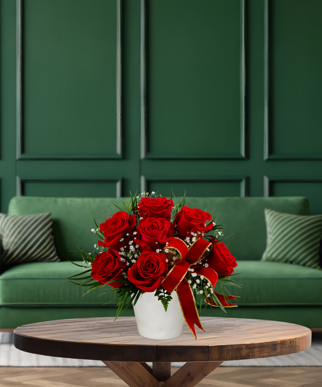 Red Bow Classic Christmas arrangement with red roses, baby's breath, green foliage, and a red velvet bow in a white vase