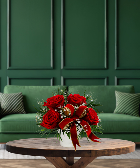 Red Bow Classic Christmas arrangement with red roses, baby's breath, green foliage, and a red velvet bow in a white vase