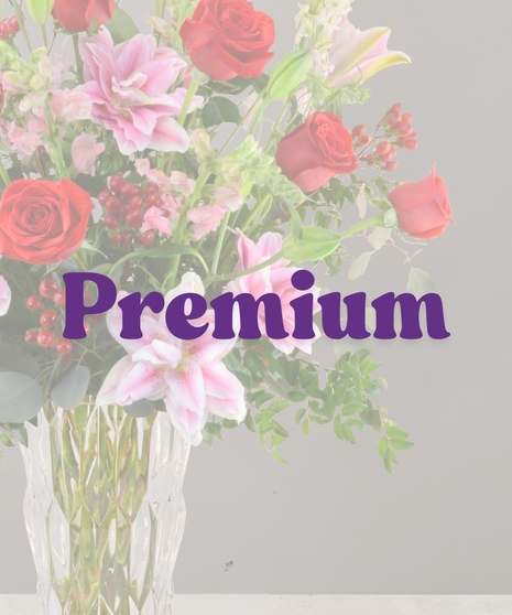 Romance Me anniversary bouquet with red roses, pink rose lilies, snapdragons, and red berries in a tall glass vase