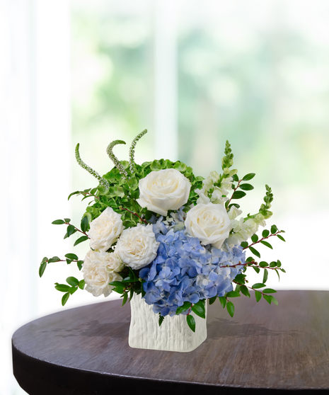 Legion of Bloom exclusive Seahawks flower arrangement with white roses, blue hydrangeas, green hydrangeas, snapdragons, and veronica in a textured white vase for Super Bowl LX