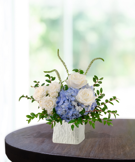 Legion of Bloom exclusive Seahawks flower arrangement with white roses, blue hydrangeas, green hydrangeas, snapdragons, and veronica in a textured white vase for Super Bowl LX