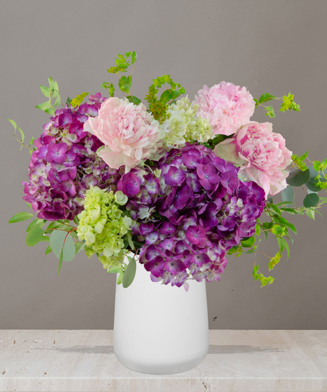 Sophie flower arrangement with lavender hydrangeas, pink peonies, and soft green accents in a modern white vase – part of Billy Heroman’s Signature Collection.