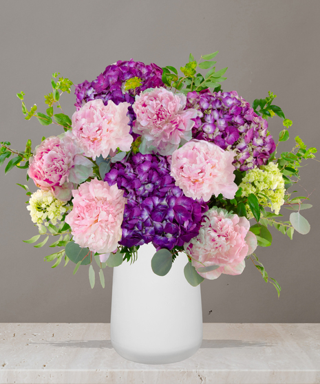 Sophie flower arrangement with lavender hydrangeas, pink peonies, and soft green accents in a modern white vase – part of Billy Heroman’s Signature Collection.