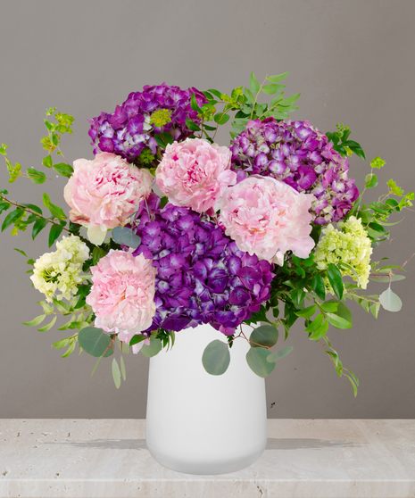 Sophie flower arrangement with lavender hydrangeas, pink peonies, and soft green accents in a modern white vase – part of Billy Heroman’s Signature Collection.