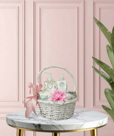 Serenity for Mom gift basket with cotton & linen-scented spa products, floral accents, and ivory ribbon in a woven basket – Mother’s Day gift idea.