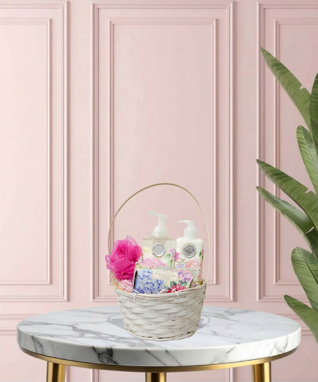 Serenity for Mom gift basket with cotton & linen-scented spa products, floral accents, and ivory ribbon in a woven basket – Mother’s Day gift idea.