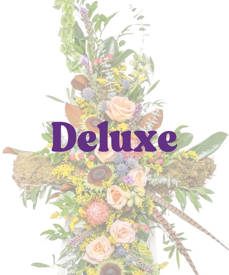 The Great Outdoors Cross Stand with peach roses, pincushion protea, moss, berries, and feathers on a white easel