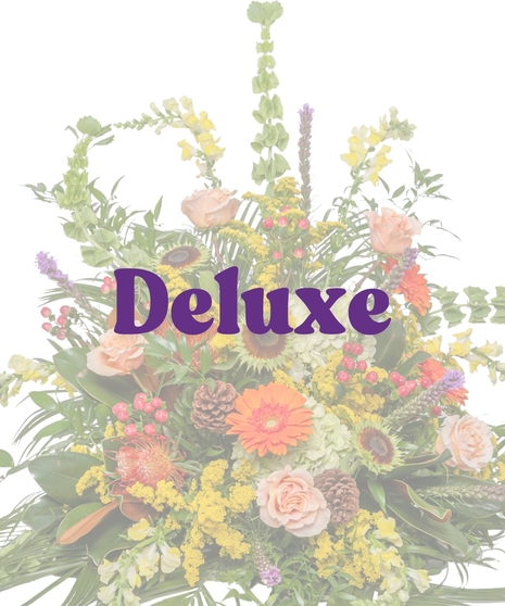 Nature-inspired floor sympathy arrangement with roses, gerbera daisies, pinecones, and feathers from Billy Heroman’s in Baton Rouge