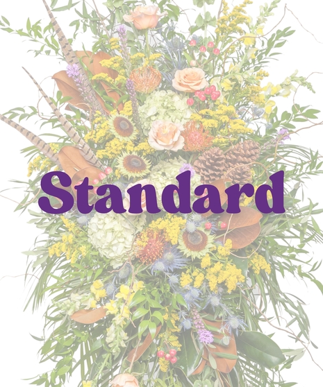 The Great Outdoors Funeral Stand with peach roses, hydrangeas, protea, feathers, pinecones, and rustic greenery on a white easel