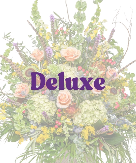 The Great Outdoors Urn Arrangement with peach roses, green hydrangeas, protea, feathers, and rustic greenery in a tall urn