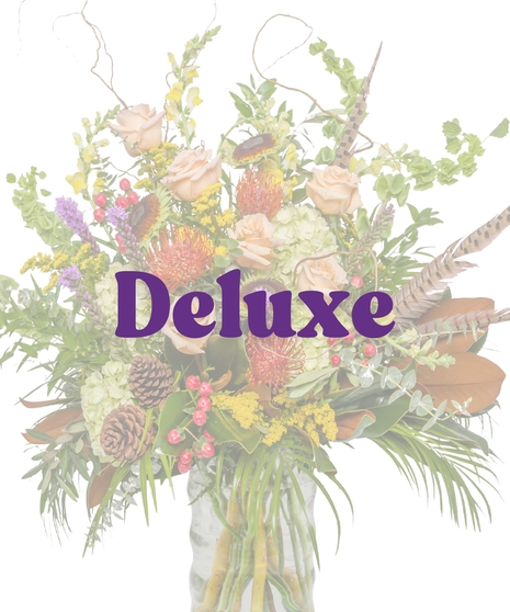 The Great Outdoors Vase Arrangement with peach roses, protea, pinecones, hydrangeas, berries, and pheasant feathers in a clear glass vase