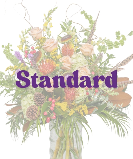 The Great Outdoors Vase Arrangement with peach roses, protea, pinecones, hydrangeas, berries, and pheasant feathers in a clear glass vase