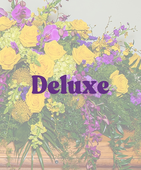 Tiger Pride Casket Cover with yellow roses, purple orchids, green hydrangeas, and flowing greenery