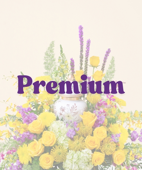 Tiger Pride Cremation Arrangement with yellow roses, purple orchids, green hydrangeas, and bright chrysanthemums surrounding a decorative urn