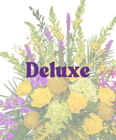 Tiger Pride Floor Funeral Arrangement with yellow roses, purple orchids, green hydrangeas, and tropical foliage