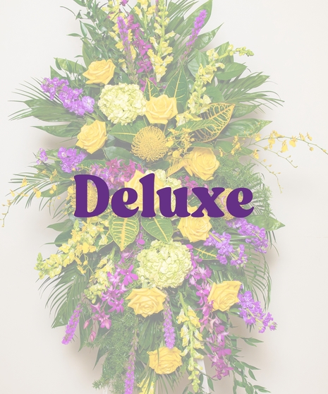 Tiger Pride Funeral Stand with yellow roses, purple orchids, snapdragons, green hydrangeas, and tropical foliage on a white easel