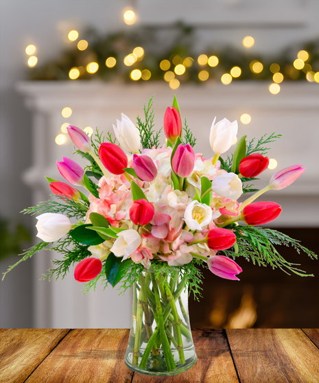 A stunning arrangement of dark purple, red, and pink tulips in a vase.
