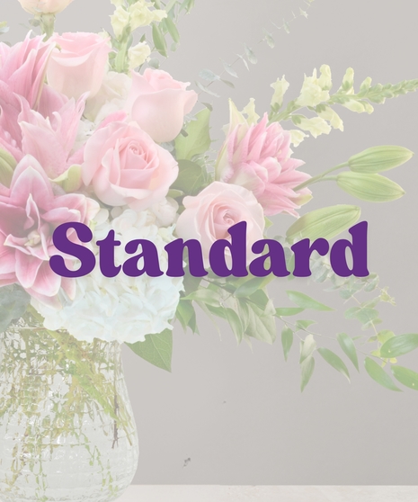 Unforgettable flower arrangement with pink roses, stargazer lilies, white hydrangeas, and eucalyptus in a tall clear vase