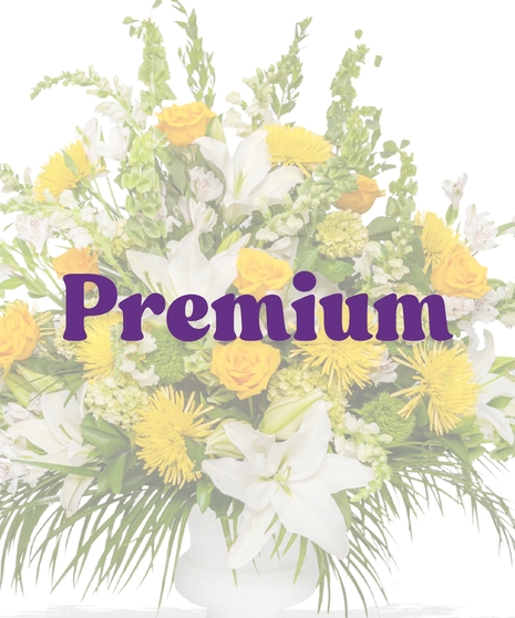 Tall pedestal urn arrangement with yellow roses, white lilies, spider mums, and tropical foliage from Billy Heroman’s in Baton Rouge