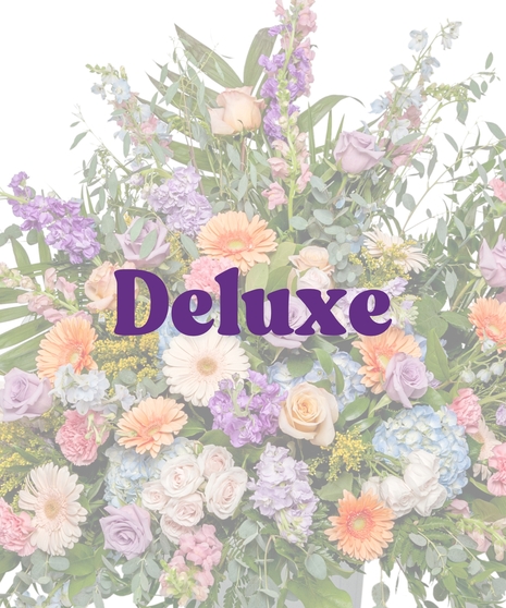 Pastel urn flower arrangement with roses, gerberas, hydrangeas, and spring blooms in a classic pedestal vase from Billy Heroman’s in Baton Rouge