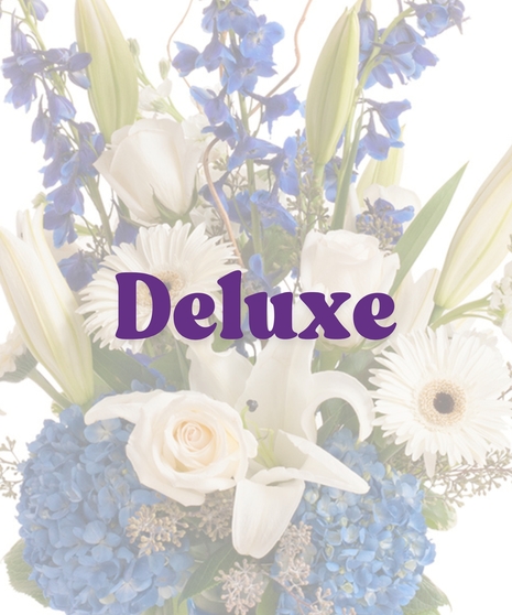 Sympathy vase with white roses, lilies, and blue hydrangeas, accented with blue ribbon and curly willow