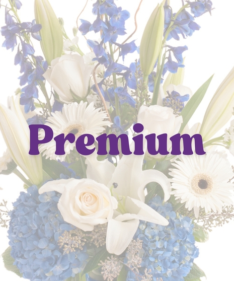 Sympathy vase with white roses, lilies, and blue hydrangeas, accented with blue ribbon and curly willow