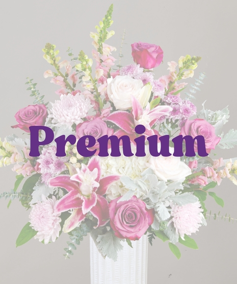 Viola flower arrangement with rose lilies, purple roses, snapdragons, hydrangeas, and eucalyptus in a tall white vase