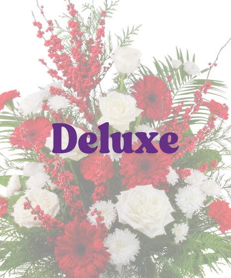 Winter Berry funeral floor arrangement with white roses, red gerberas, red carnations, white chrysanthemums, red berries, and seasonal winter greenery in a white container.