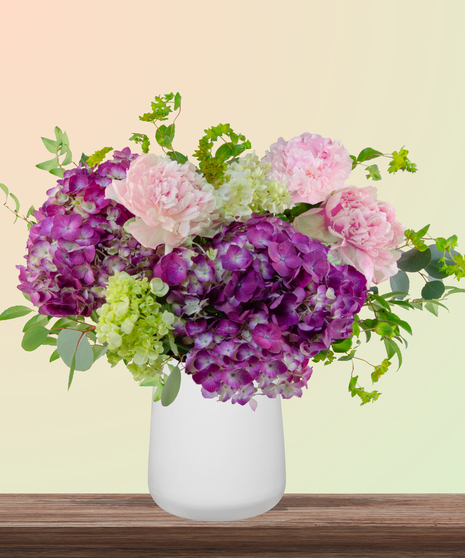 World Class Mom flower arrangement with pink peonies, lavender and green hydrangeas in a modern white vase – part of Billy Heroman’s Signature Mother’s Day Collection.