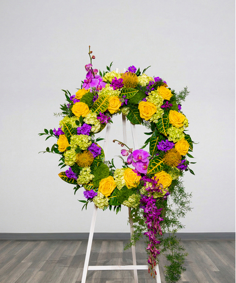 Tiger Pride Funeral Wreath Stand with yellow roses, purple orchids, and cascading greenery