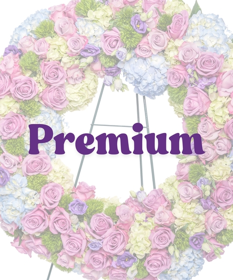 Spring funeral wreath with pastel pink, lavender, blue, and green florals on easel by Billy Heroman’s in Baton Rouge, LA
