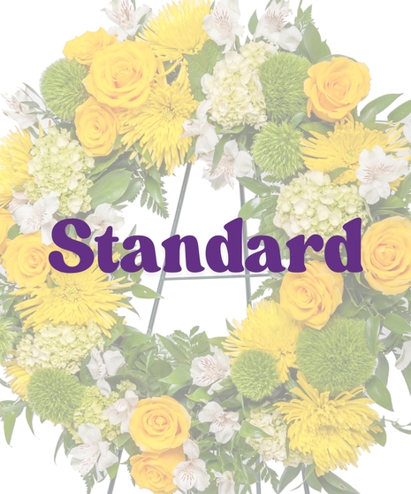 Yellow and white funeral wreath with roses, mums, and alstroemeria on an easel from Billy Heroman’s in Baton Rouge