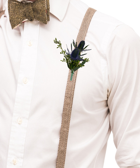 A simple boutonniere made with blue thistle and seeded eucalyptus