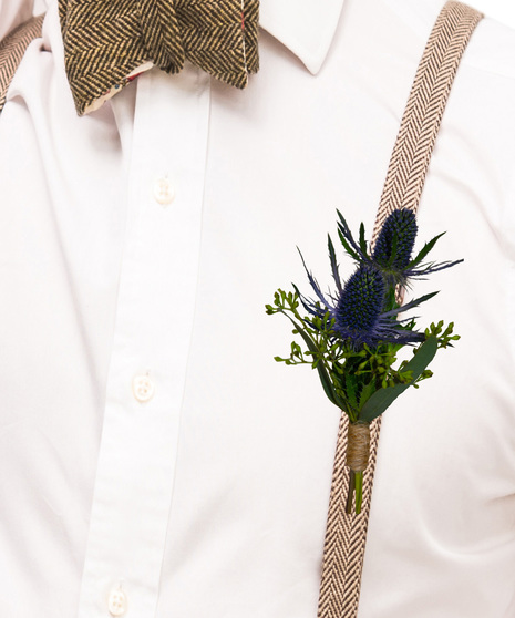 A simple boutonniere made with blue thistle and seeded eucalyptus