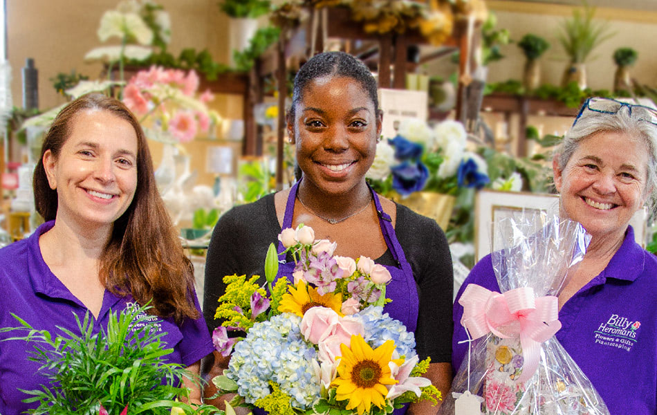 A trio of happy employees pose with their favorite gift baskets